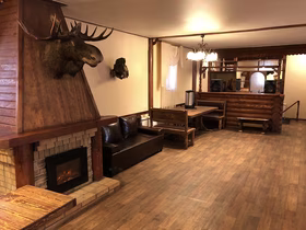 Каминный зал с горящим камином и головой лося — снять дом для банкета, отдых в Тюмени